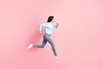 Fototapeta na wymiar Full length profile photo lady jumping running speed flying in air wear blue pullover jeans isolated pink color background