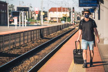 Man with a mask waiting for a train during Covid19 pandemic