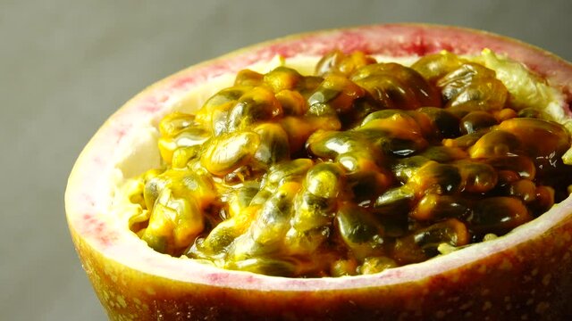 4K cross-section of a puple passion fruit Macro shot of sliced fresh exotic passion fruit fruit rotating 