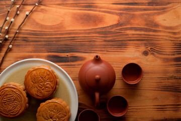Top view of rustic table with traditional moon cakes, tea set and copy space