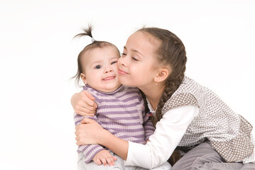 Two little girls sisters together on a white background