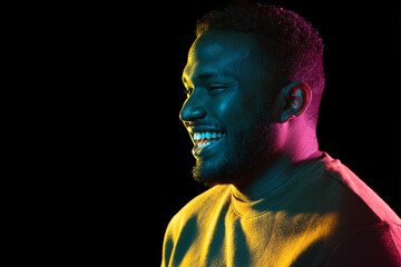 people and ethnicity concept - portrait of happy smiling young african american man over black background