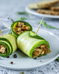 Three zucchini rolls on a round plate
