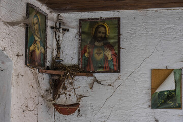 old holy pictures with cross on the wall from a farmhouse