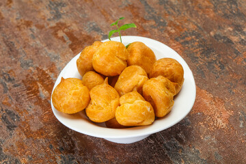 Sweet tasty profiteroles heap in the bowl