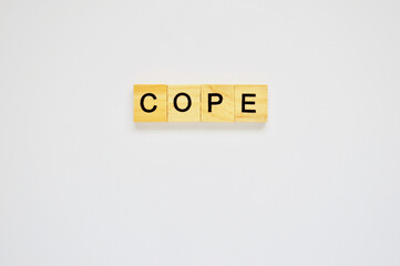 Word cope. Wooden blocks with lettering on top of white background. Top view of wooden blocks with letters on white surface