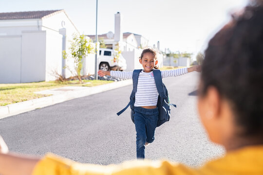 Little elementaty student girl running to mother after school
