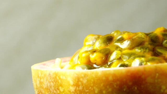4K cross-section of a puple passion fruit Macro shot of sliced fresh exotic passion fruit fruit rotating 