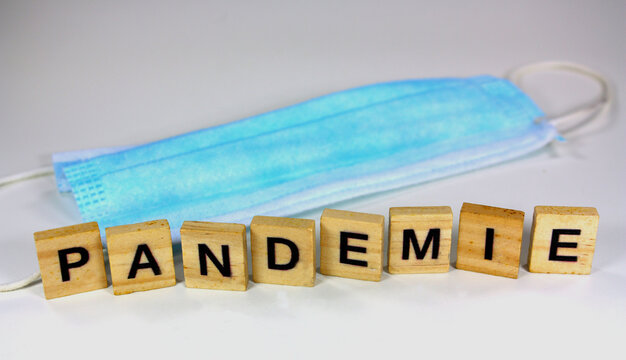 Blaue Gesichtsmaske und Textbausteine mit dem Titel PANDEMIE