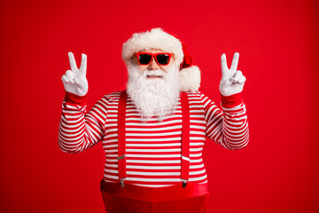 Portrait of his he nice attractive handsome cheerful cheery optimistic Santa showing double v-sign having fun party good mood isolated on bright vivid shine vibrant red color background