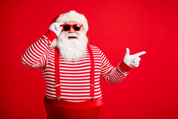 Fototapeta na wymiar Portrait of his he nice handsome attractive cheerful cheery bearded fat gray-haired Santa demonstrating copy space gift present surprise isolated on bright vivid shine vibrant red color background