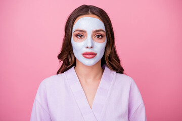 Photo portrait of young woman with brown wavy hair applied nourishing mask on smooth skin doing spa procedures isolated on pink color background