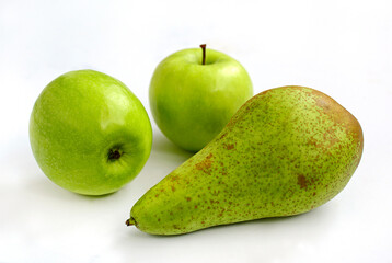 Two green ripe apples and pear on a white background
