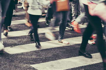 Blurred people crossing the street on a zebra crossing. Toned
