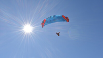 Kitegleiten im Himmel mit Sonne, rot und blauer Kite Fallschirm mit Gleitschirm Gleiter
