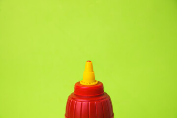 red pot of ketchup on color background