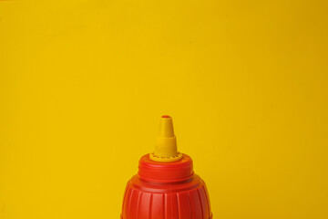 red pot of ketchup on color background