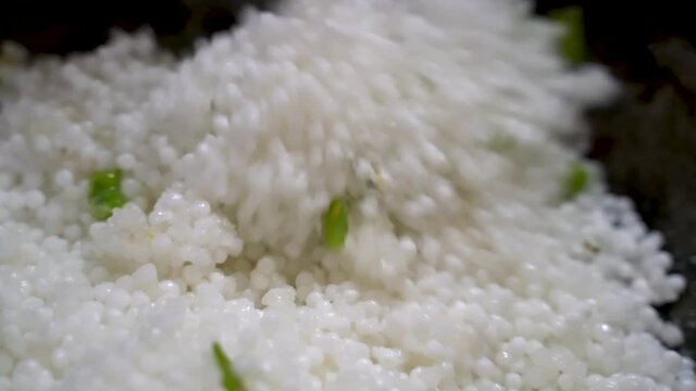 Sago With Chopped Green Chili Slowly Stirred By A Flat Ladle In Kadai. - Close Up Shot