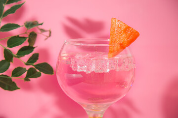 gin and tonic glass on pink background