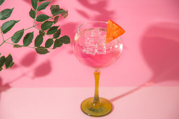 gin and tonic glass on pink background