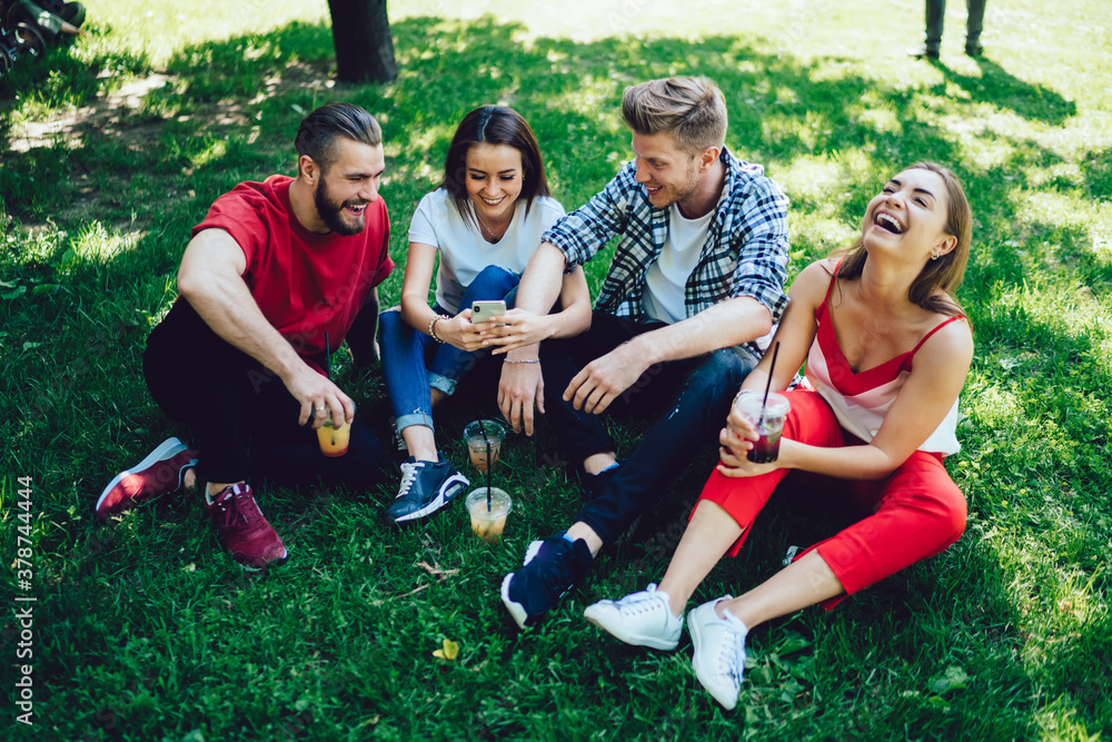 Poster cheerful female blogger using cellphone device for social networking during double date with friendl