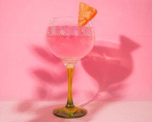 gin and tonic glass on pink background