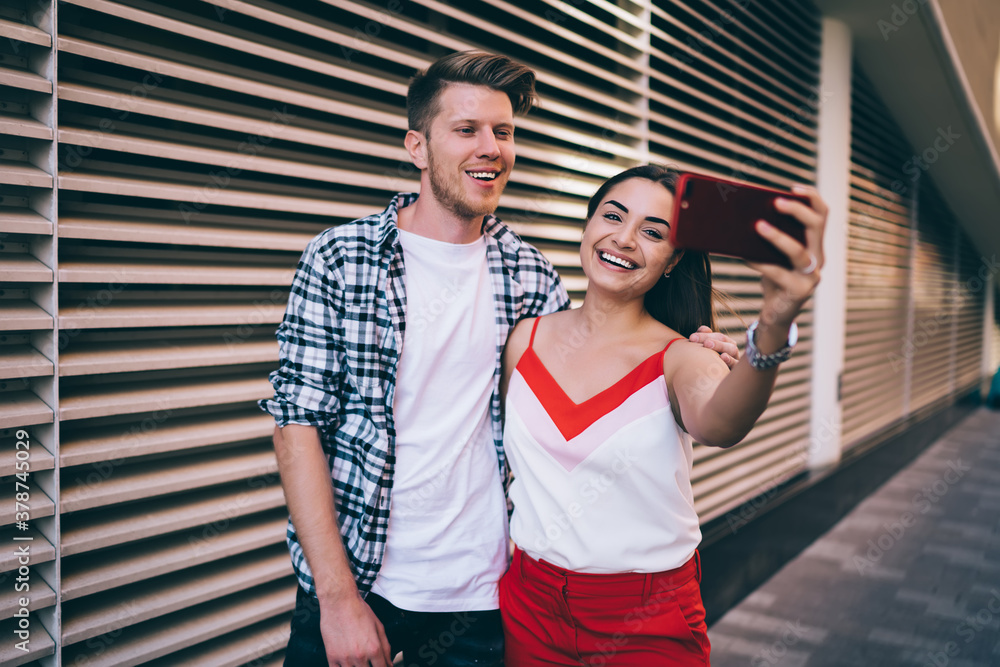 Aufkleber happy male and female users smiling at camera while making selfie content for sharing to social netw