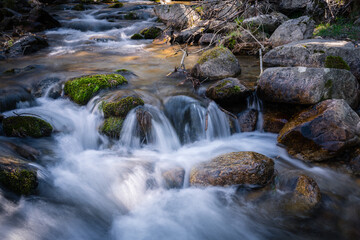 Fototapeta na wymiar River water flows among the rocks and forms small waterfalls, Rascafría, Madrid, Spain