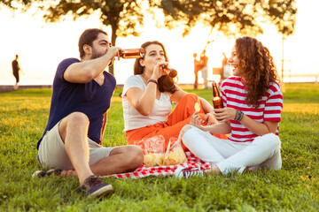 Three friends sitting on the grass in the park