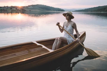 Foto op Canvas Young woman paddling canoe  © yossarian6