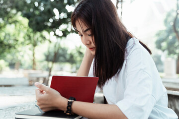Fototapeta premium University student reading a book at park.