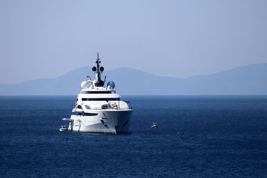 Luxury Yacht With Helipad And Helicopter Sailing In A Sea, Front View. White Futuristic Boat On Mountain Island Background