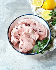 Raw fresh meat (pork) in bowl on gray background