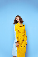 Woman looking to the side and yellow coat with buttons fashionable clothes