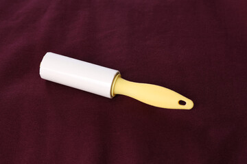 New lint roller with yellow handle on red fabric