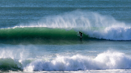 Surfer having fun riding waves on a sunny day