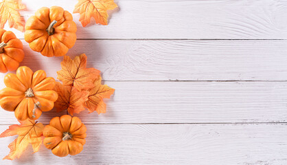 Autumn background decoration from dry leaves and pumpkin on  wooden background. Flat lay, top view with copy space for Autumn, fall, Thanksgiving concept.