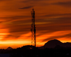 Tower amidst mountains in sunset. the shades of clouds in the sky is something that enhances beauty of the picture.