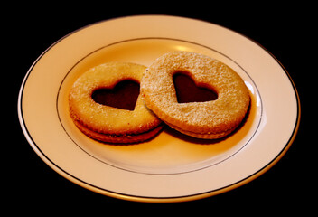 Traditional Linzer cookies with strawberry jam on a black background