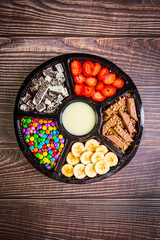 Acai frozen with banana, granola, chocolate and candies for share. A roulette for share.