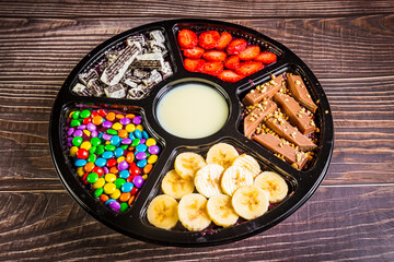 Acai frozen with banana, granola, chocolate and candies for share. A roulette for share.