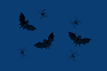 Little black toys bats and spiders on dark blue background. Halloween concept