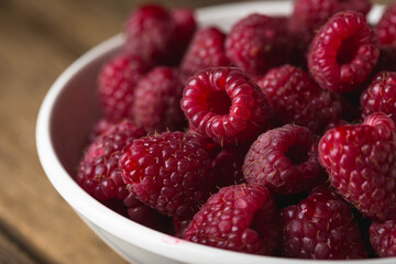 Fresh raspberries in a bowl on a wooden table