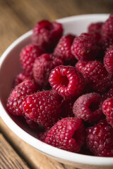 Fresh raspberries in a bowl on a wooden table