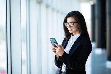 Young business woman use phone for text or surfing in internet in modern office. Office concept