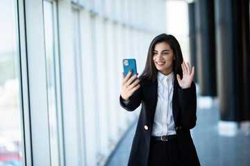 Businesswoman making video call to business partner using laptop, looking at screen with virtual web chat, contacting client by conference, talking on phone in office