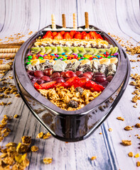 Acai frozen with banana, kiwi fruit, granola and candies for share. A boat for share.