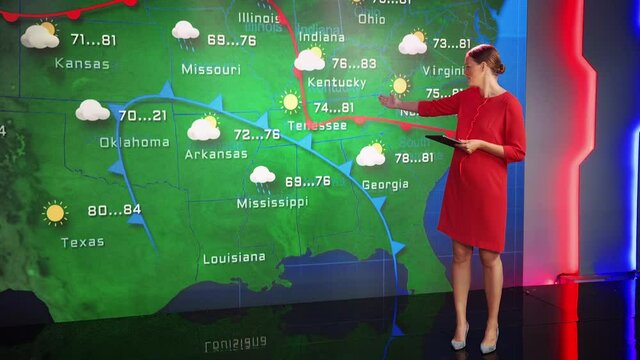 Live Weather News Studio with Beautiful Professional Female Reporter wearing Gorgeous Dress and Holding Digital Tablet Standing Beside Wall Screen and Gesturing at Weather Synoptic Map of U.S.