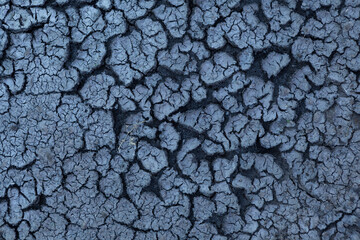 Dark dry soil with cracks. Abstract background. Season without rain. Global warming, climate change...