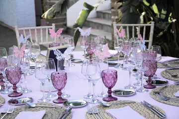 bridal table and table setting of a wedding, marriage or celebration with decoration and pink details in the garden